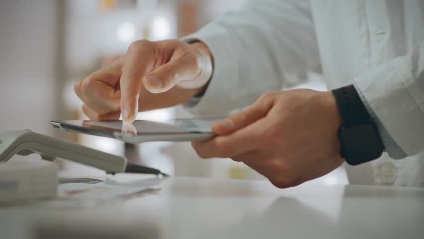 Medicine. A pharmacist uses tools responsibly and looks at a tablet screen in a pharmaceutical center. European worker enters data using a touchpad adheres to the rules of the pharmacy, work