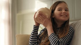 Happy little girl putting coins pennies pig piggy bank shaking finances save money dream child enjoy currency investment economy wealth planning kid female daughter budget cash security smile business - Powered by Shutterstock - Get 15% off with code: PIKWIZARD15