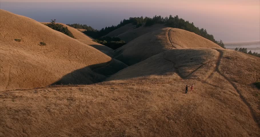 Male and female ballet dancer doing contempoary dance on dry grassy hills in Mt Tamalpais as sunset. San Francisco, California, United States of America.
