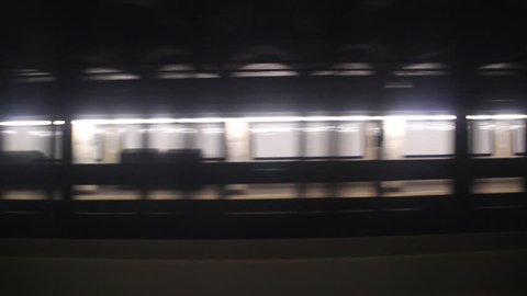 A subway train passes a station underground