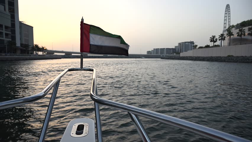 A serene boat ride through Dubai Marina Yacht Club at sunset, capturing the beauty of the skyline and the iconic UAE flag waving in the breeze