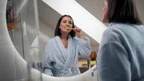 Portrait of attractive young lady brushing teeth near mirror - Powered by Shutterstock - Get 15% off with code: PIKWIZARD15