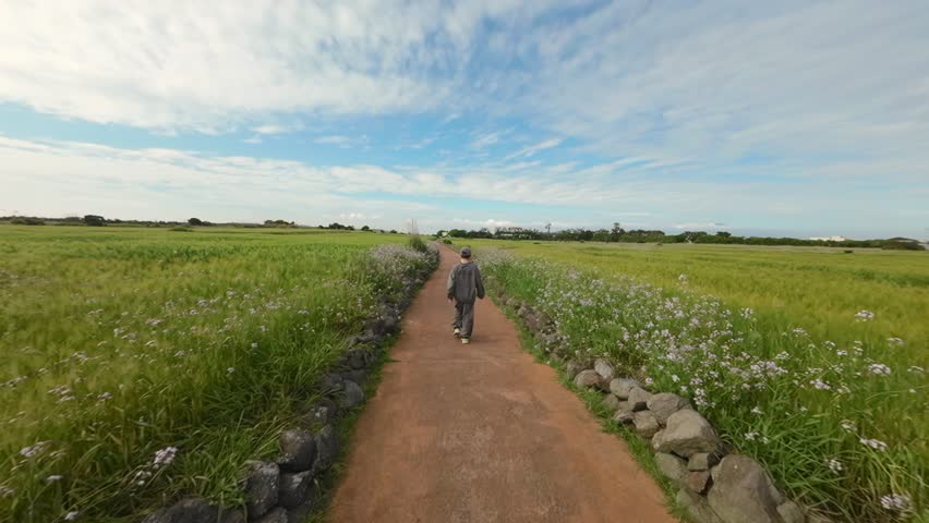 A slow-motion shot of a guy walking in Jeju, South Korea.