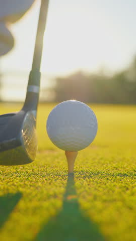 VERTICAL VIDEO. Male hand in a golf glove puts the ball on the field. Golfer placing golf ball on the tee at golf course. Close up