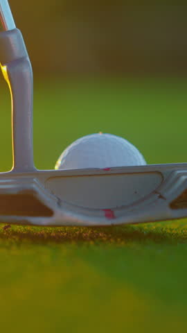 VERTICAL VIDEO. Male hand in a golf glove puts the ball on the field. Golfer placing golf ball on the tee at golf course. Close up