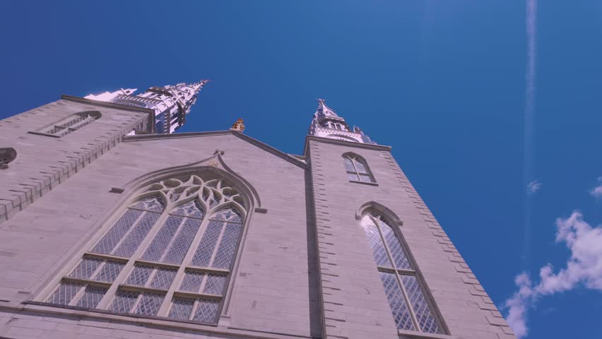 A low angle shot of the majestic towers of The Notre-Dame Cathedral Basilica under blue clear sky in Ottawa, Canada