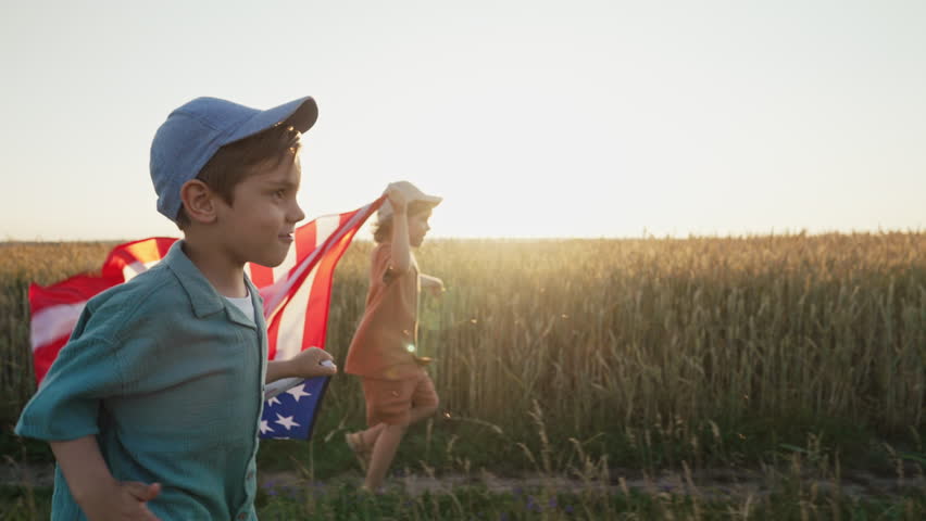 Cute little boys - American patriot kids running with national flag on open area countryside road.USA, 4th of July - Independence day, celebration. US banner,memorial Veterans,election, America, labor