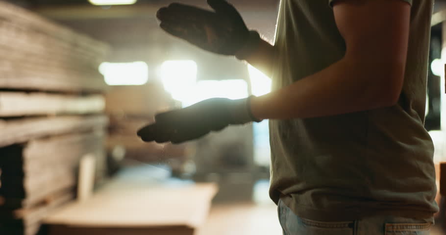 Dust, hands and person in carpentry workshop for creative, construction or manual labor occupation. Industry, job and manufacturing with professional carpenter in woodworking factory for production