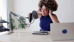 Latina woman recording live podcast radio - Content creator and media communication concept. Vertical video - Powered by Shutterstock - Get 15% off with code: PIKWIZARD15