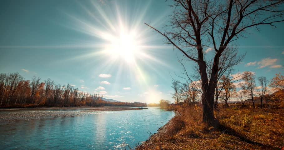 Mountain river time-lapse at the summer or autumn day time. Wild nature, clear blue water and dry trees. Sun rays and light evening wind. Motorised dolly slider movement
