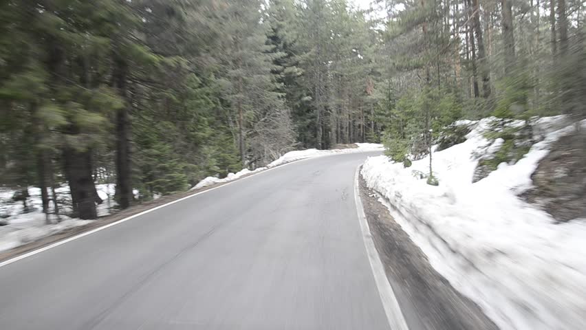 Drive a curve on a snow winter road POV, ski resort Bansko Bulgaria; asphalt