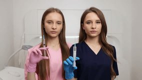 Two Young Women Nurses With Syringes, Smiling. Twins. - Powered by Shutterstock - Get 15% off with code: PIKWIZARD15