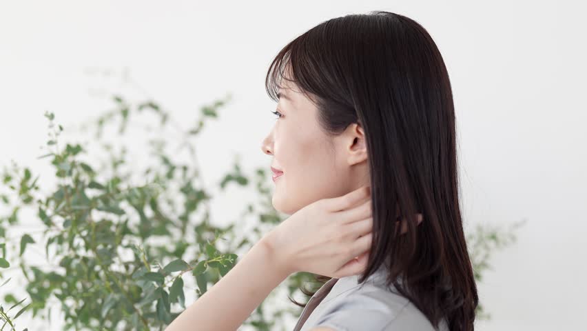 portrait of attractive asian woman looking back and blowing her hair,
beauty concept image.
