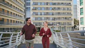 Couple jogging together city street. Active man woman talking during workout running in fitness gear. Urban athletes enjoying cardio training in sunny morning. Multicultural sport people in town. - Powered by Shutterstock - Get 15% off with code: PIKWIZARD15