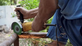 An angle grinder cutting tool in action during iron pipe cutting with red metal sparks in a construction and renovation scene in Dehradun City, Uttarakhand, India. - Powered by Shutterstock - Get 15% off with code: PIKWIZARD15