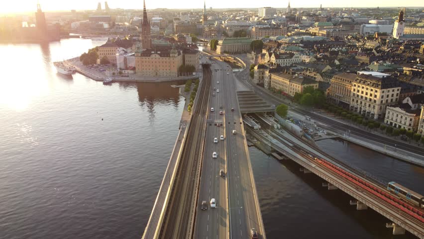 Cars and traffic on the central bridge road, Slussen and Gamla Stan, aerial view, late afternoon sun, old town and Riddarholmen. Summer in Stockholm, Sweden. Metro and railway