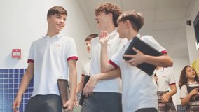 Group of teenage in uniform smiling and talking while holding tablets at school. - Powered by Shutterstock - Get 15% off with code: PIKWIZARD15