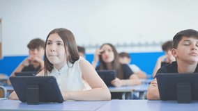 Schoolchildren with tablets in a classroom, focused on the lesson being taught. - Powered by Shutterstock - Get 15% off with code: PIKWIZARD15