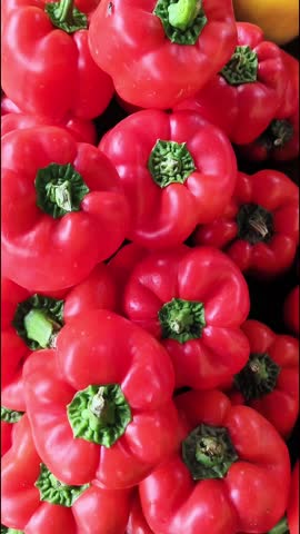 Red capsicum or Shimla Mirch, piled-heaped at a vegetable and fruit shop, a top view close up video. It's a genus of flowering plants in the nightshade family Solanaceae.