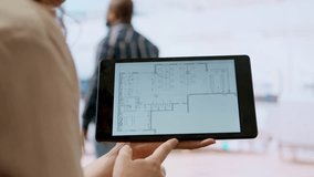 Real estate agent and client evaluating blueprints and discussing the architectural layout of new office space during office tour. Businessman strategizing corporate office relocation deal. Camera A. - Powered by Shutterstock - Get 15% off with code: PIKWIZARD15