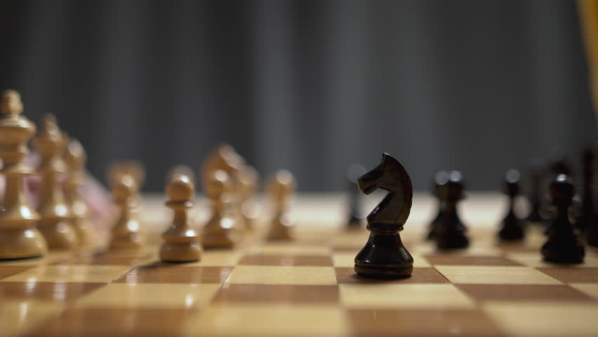 Chess piece knight. male hand player putting piece on board. Wooden chess pieces. Close-up