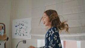 Overjoyed toddler jumping bed having fun with unrecognizable mom at home closeup. Positive kid girl in pyjama fooling around at white bedding. Happy child holding teddy bear feeling carefree indoors - Powered by Shutterstock - Get 15% off with code: PIKWIZARD15