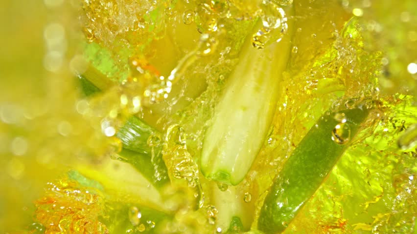 Super Slow Motion Shot of Green Apple Cuts Followed by Camera Splashing into Juice at 1000 fps.