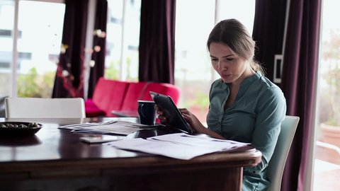 Businesswoman working with tablet computer and documents in home
 Stock Video