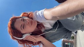 Young woman dancing with headphones on the street.Vertical video - Powered by Shutterstock - Get 15% off with code: PIKWIZARD15