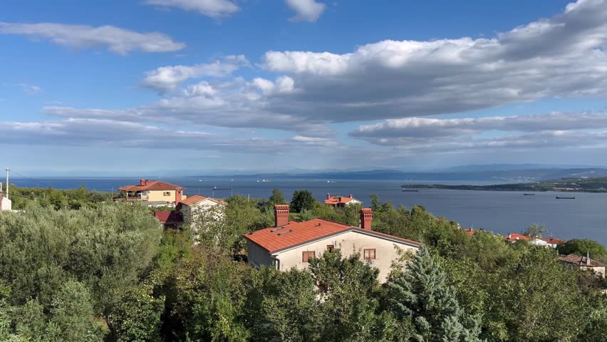 A beautiful view of a town with a large body of water in the background. The houses are small and the sky is cloudy