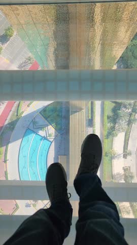 POV of  male  walk on a glass floor  in Dubai Frame.