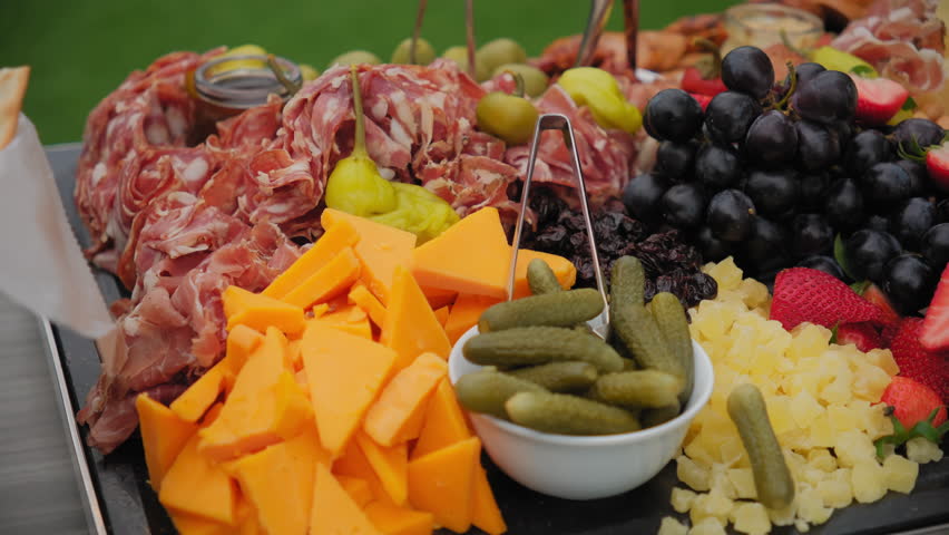 Meat plate with assortment of various tasty, french or Italian appetizers, sliced prosciutto,, ham on event