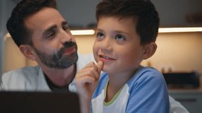 Family enjoying laptop movie relaxing at comfortable home closeup. Happy daddy son spectators having nighttime leisure in modern living room with computer. Relaxed parent child discussing tv show - Powered by Shutterstock - Get 15% off with code: PIKWIZARD15