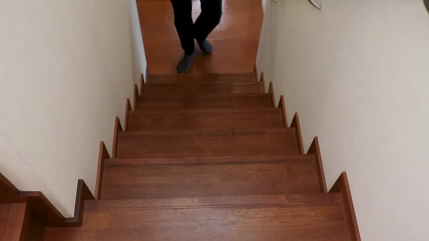 A man walking up the stairs with his hand on his knee