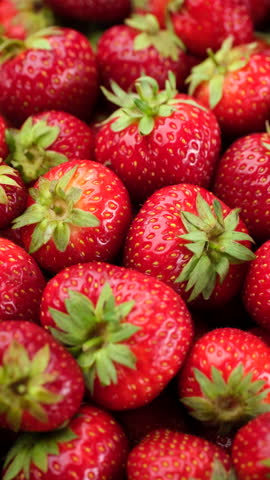 Fresh strawberries with green tails close up, rotation. Strawberry harvest. Summer Dessert
