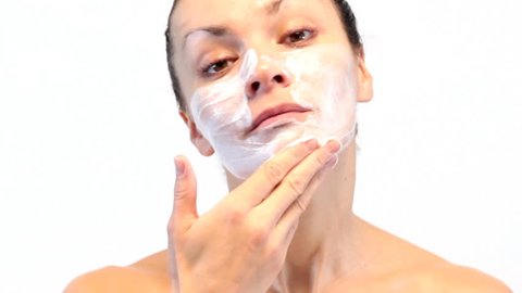 woman doing cosmetic mask on her face
