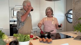 Senior woman in the kitchen makes her husband taste the cooked vegetables directly from the pan. Elderly couple in the kitchen preparing dinner - Powered by Shutterstock - Get 15% off with code: PIKWIZARD15