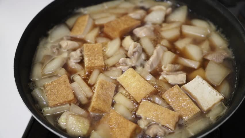 Cooking stew of chicken thighs, daikon radish and deep-fried tofu
