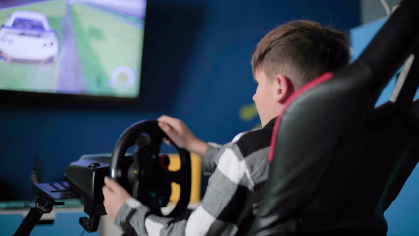 passion for computer games, male child modern video games on console and uses modern gadgets while sitting in kids room