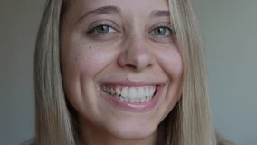 Young caucasian blonde smiling woman with perfect white even teeth on a grey background. Oral hygiene, dental health care. Teeth whitening. Dentistry, beautiful smile. Close up - Powered by Shutterstock - Get 15% off with code: PIKWIZARD15