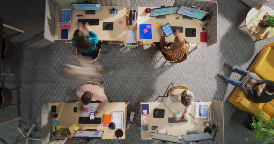 Top Down View in Timelapse: Diverse Team Working in a Creative Office. Busy Corporate Workspace With People Talking, Using Desktop Computers, and Moving Around. Productive Environment Concept.