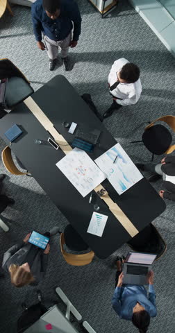 Vertical Screen Zoom Out Top Down View: Diverse Team Of Business Professionals With Laptops Entering The Conference Room And Sitting Behind Table To Discuss Financial Data, Project Mindmap in Office.
