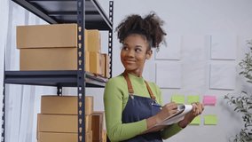 Smiling warehouse worker document for inventory check in slow motion. Organized boxes and notes on wall. Ideal for logistics, supply chain, and workplace efficiency concepts - Powered by Shutterstock - Get 15% off with code: PIKWIZARD15