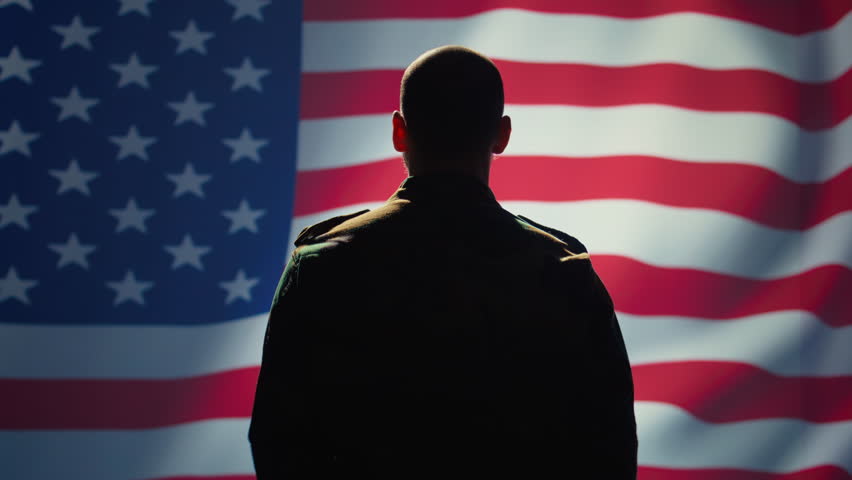 American patriot doing salute hand gesture towards USA flag, feeling pride in serving country. United States army personnel does military greeting gesturing while listening national anthem, camera B - Powered by Shutterstock - Get 15% off with code: PIKWIZARD15