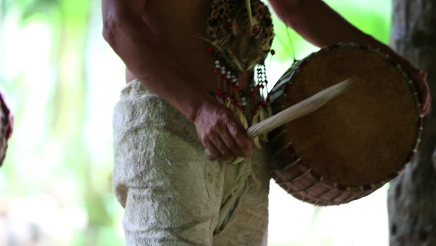 closeup of an Ecuadorian indigenous man from the Wayuri tribe playing a drum during a traditional dance in the Amazon rainforest
