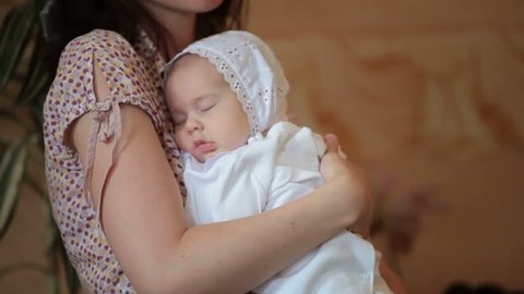 mother hugging baby at  ceremony of baptism