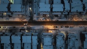 Car on road lighting by lantern during snowy winter day in small american town. Housing area with snow-covered homes at night. Aerial top down tracking shot. - Powered by Shutterstock - Get 15% off with code: PIKWIZARD15
