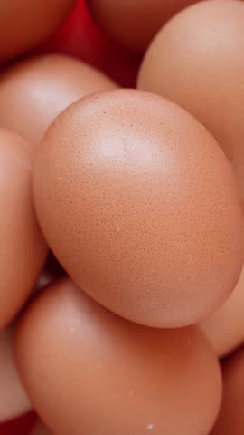 Rotating chicken egg close up. Pile of fresh raw eggs. 4k vertical concept