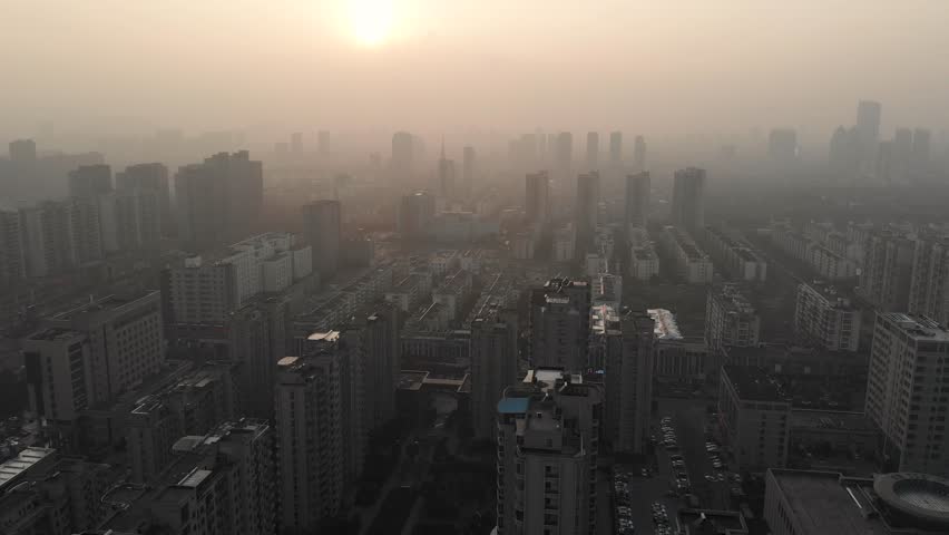 Chinese city is covered in smog. Sunset time. Pollutied city. Air Pollution