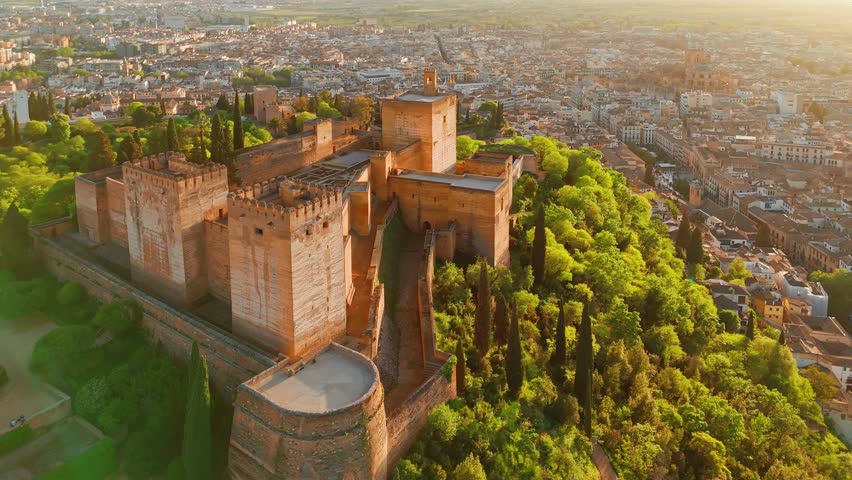 Aerial view of the historic Alhambra palace at sunset in Granada, Andalusia, Spain. The ancient Arabic fortress Alhambra during the beautiful evening. Aerial drone footage of Granada cityscape